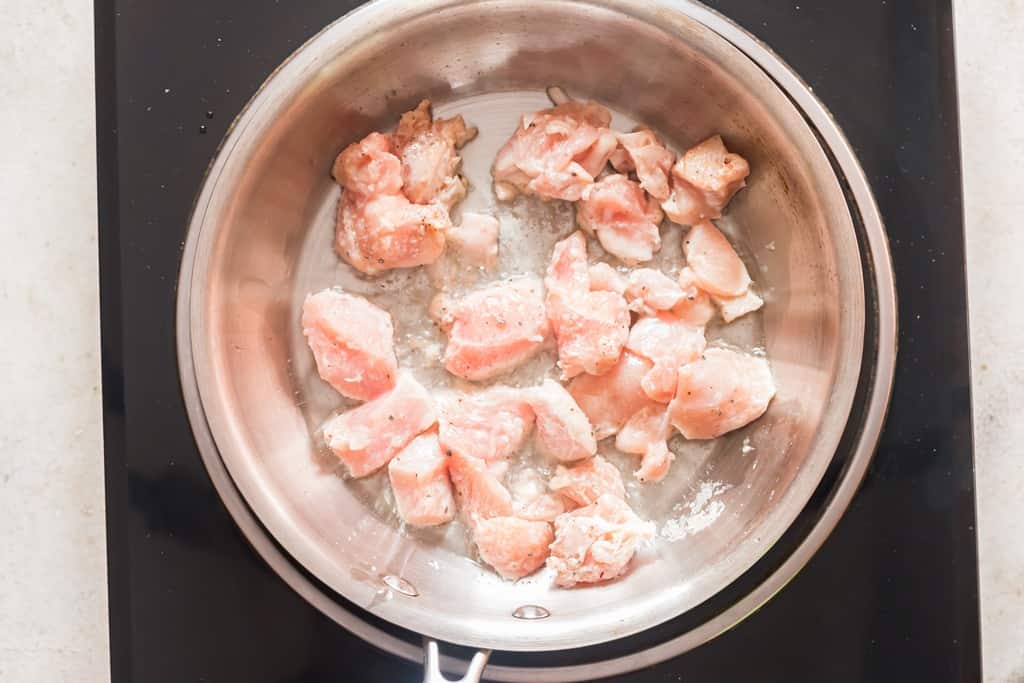 cooking marinated chicken in skillet