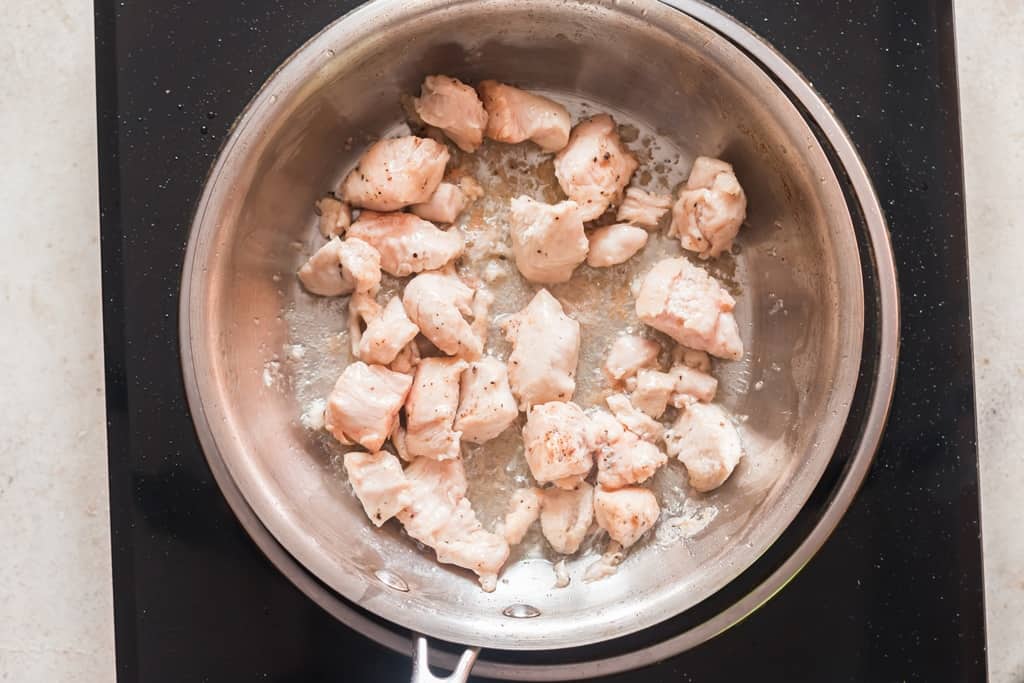 cooking marinated chicken in skillet