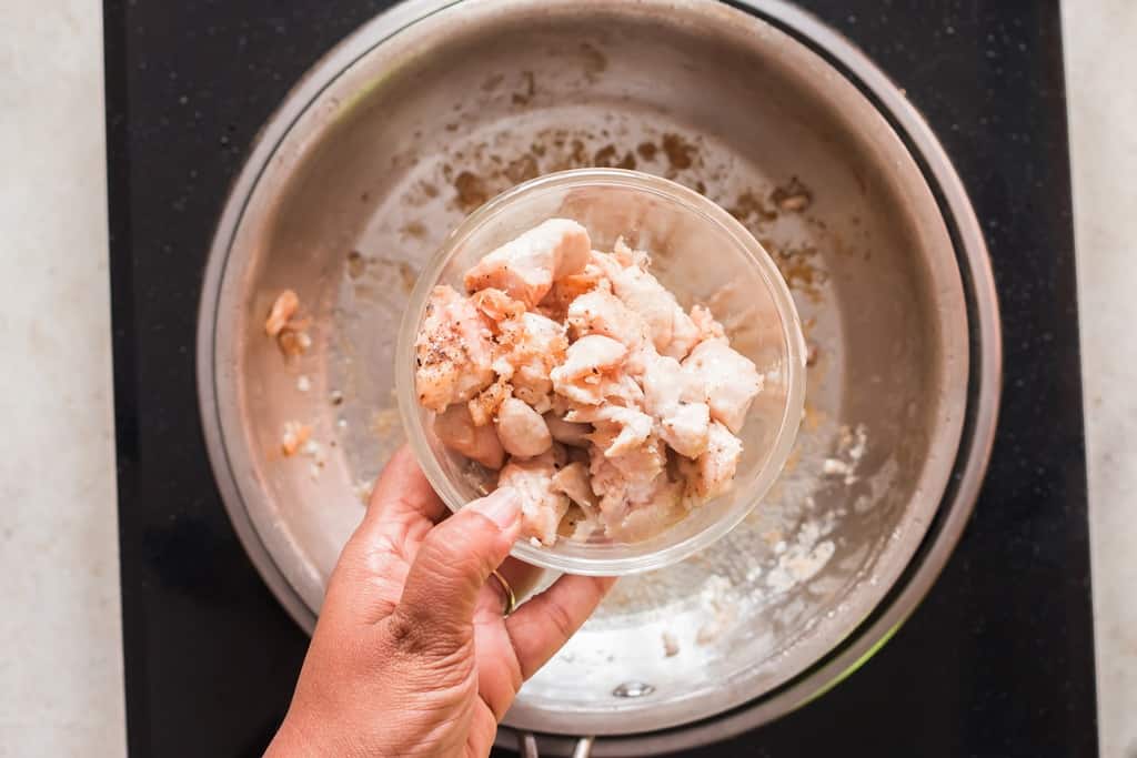 cooking marinated chicken in skillet