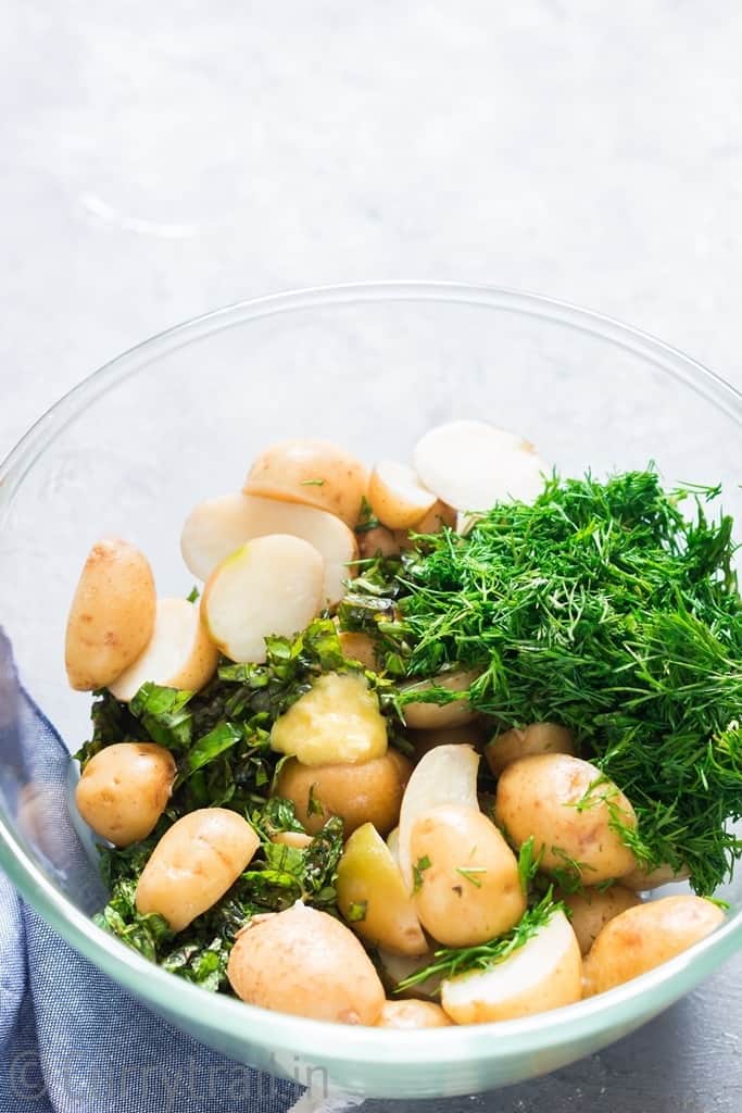 mixing in all ingredients for potato salad in a bowl