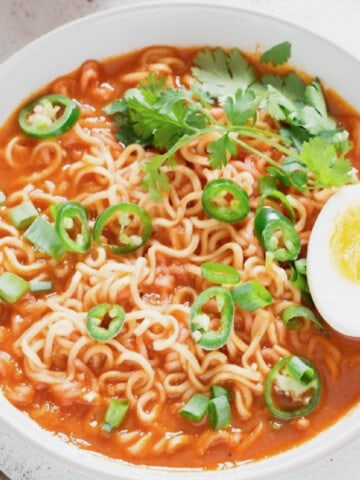 spicy sriracha ramen noodles soup topped with soft-boiled eggs.