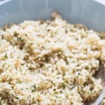 rice seasoned with herbs, and spices in a bowl with text.