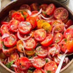 summer cherry tomato salad served in wooden salad bowl with pepper mill on side