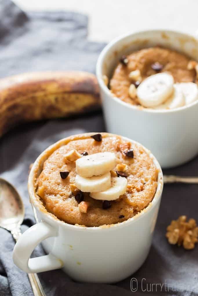 1 minute microwave banana mug cake in white ceramic mug served with banana slices