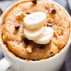 1 minute microwave banana mug cake in white ceramic mug served with banana slices
