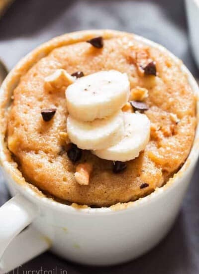 1 minute microwave banana mug cake in white ceramic mug served with banana slices