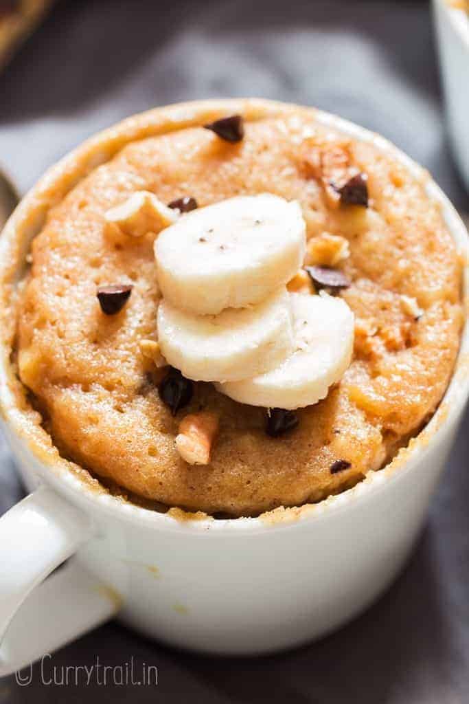 1 minute microwave banana mug cake in white ceramic mug served with banana slices