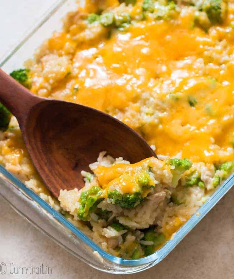 wooden spatula in cheesy broccoli rice casserole dish