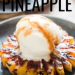 grilled pineapple served with vanilla ice cream and brown sugar rum glaze on ceramic plate