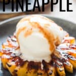 grilled pineapple served with vanilla ice cream and brown sugar rum glaze on ceramic plate