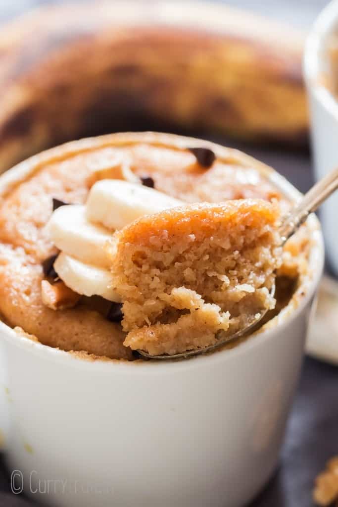 1 minute microwave banana mug cake in white ceramic mug served with banana slices