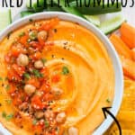 creamy roasted red pepper hummus made from scratch served in ceramic bowl with veggies and chips on sides with text overlay