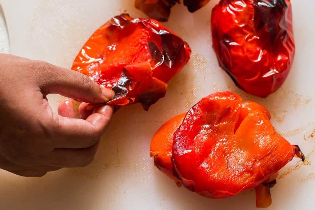 peeling skin off roasted red peppers for making hummus