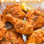 Southern fried chicken served in plate served with lemon wedges with text