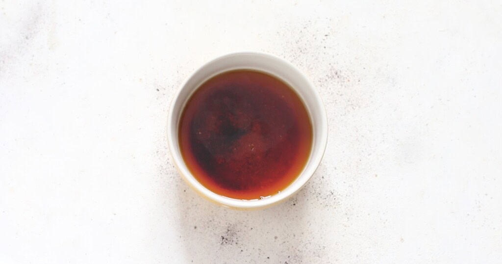 mixing rum and brown sugar in a small white bowl.