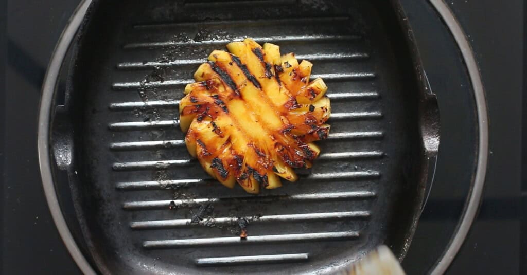 grilling pineapple slices using a grilling pan on the stovetop.
