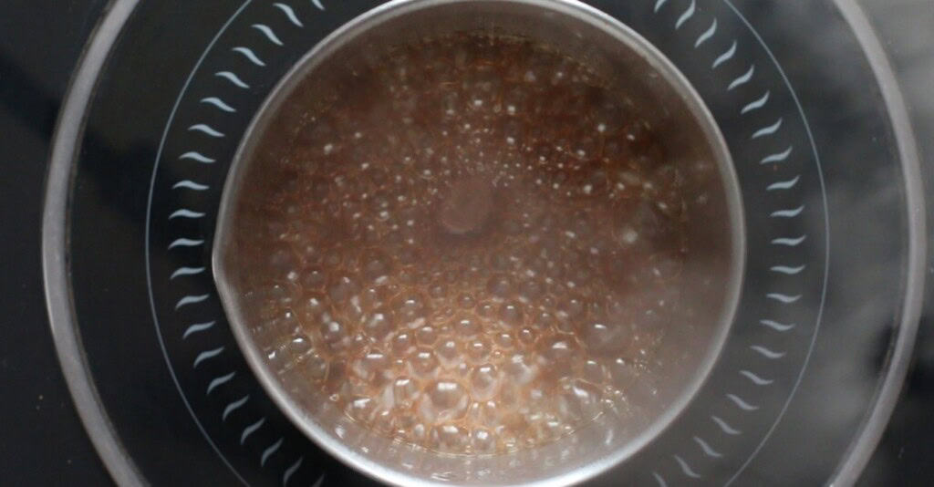 boiling brown sugar rum glaze in a saucepan.