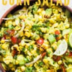 corn salad with avocados and cherry tomatoes in wooden bowl with text