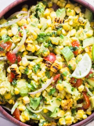 avocado corn tomato salad in wooden salad bowl