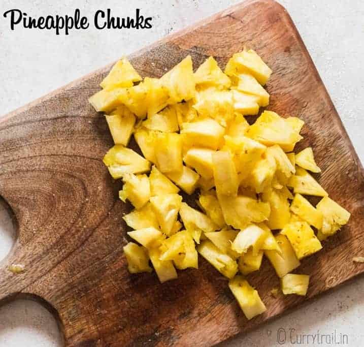 chunks of cut pineapple on wooden board