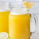 fresh homemade pineapple juice served with pineapple wedges in mason jars