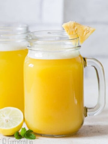 fresh homemade pineapple juice served with pineapple wedges in mason jars