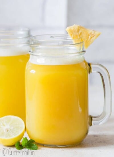 fresh homemade pineapple juice served with pineapple wedges in mason jars