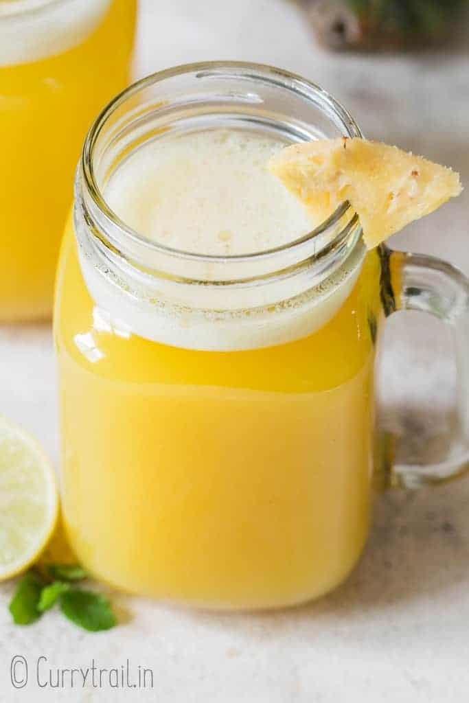 light fresh pineapple juice served with pineapple wedge in mason jar
