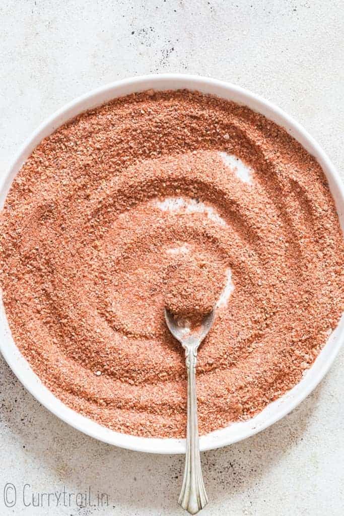 mixing in all spices to make seasoning salt on white ceramic plate