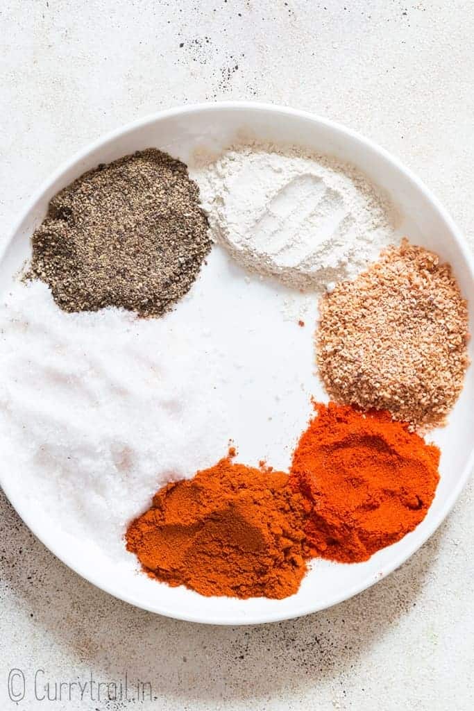 mixing in all spices to make seasoning salt on white ceramic plate