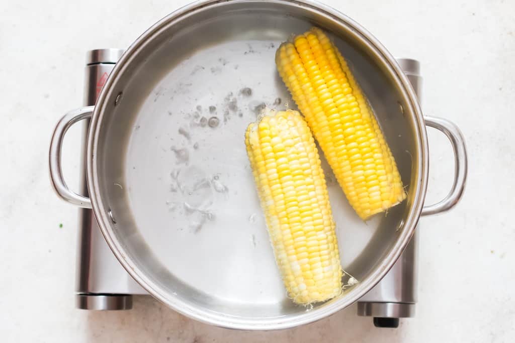 boil sweet corn in water.