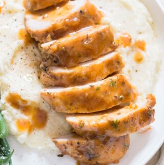 juicy chicken breasts cooked in instant pot served over mashed potatoes and green beans