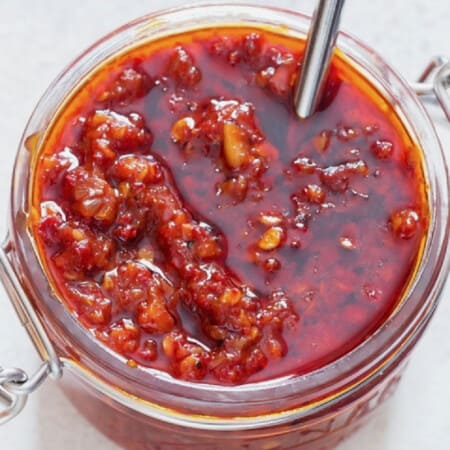 Close-up view of spicy schezwan sauce in a jar.