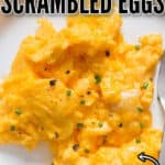 creamy, fluffy scrambled eggs on white plate with text