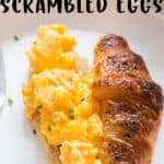 scrambled eggs served on croissant bread with text