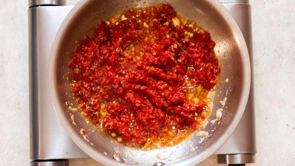 cook red chili paste in skillet.