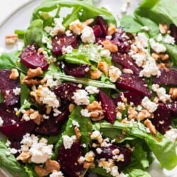 healthy arugula beetroot and feta cheese salad on white plate