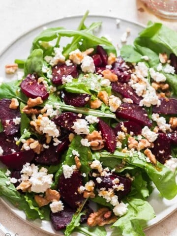 healthy arugula beetroot and feta cheese salad on white plate