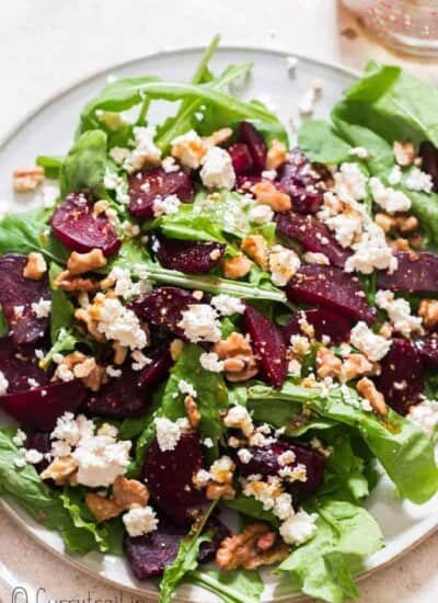 healthy arugula beetroot and feta cheese salad on white plate