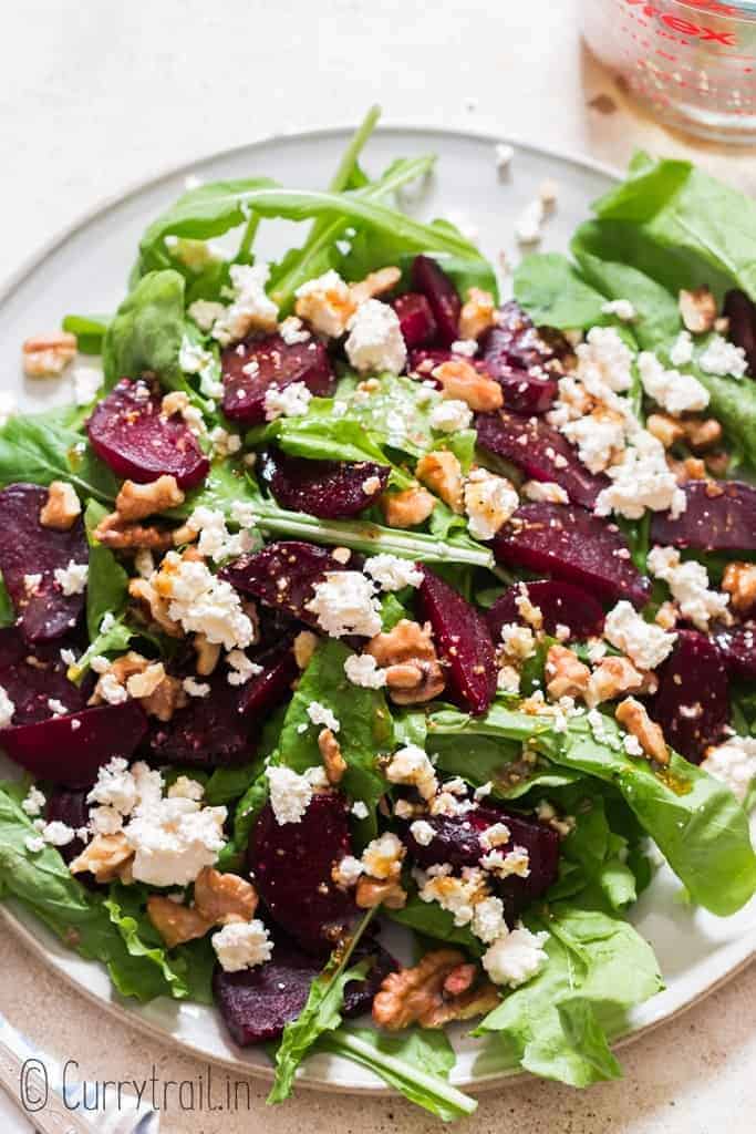 healthy arugula beetroot and feta cheese salad on white plate