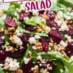 beet and feta salad with arugula leaves and walnuts on white plate with text