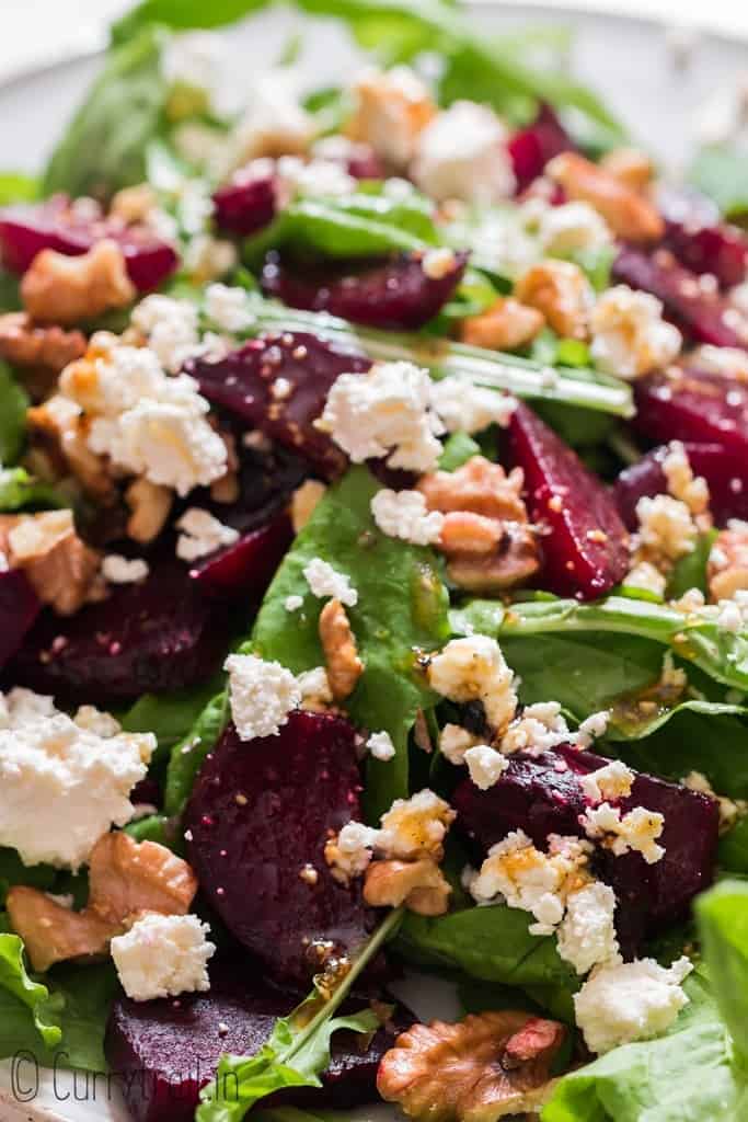 beet and feta salad with arugula leaves and walnuts on white plate