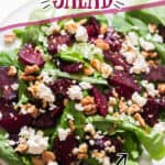 beet and feta salad with arugula on white plate with text