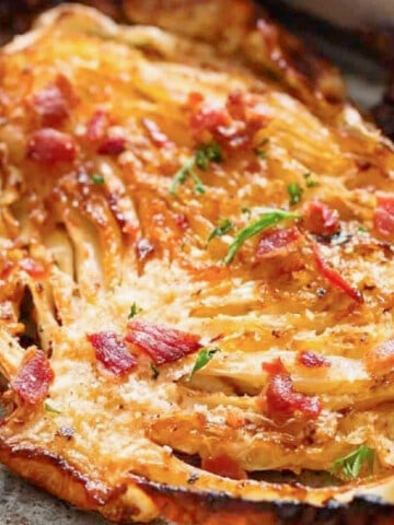 thick slice of cabbage roasted in the oven with crispy bacon and parsley sprinkled on top.