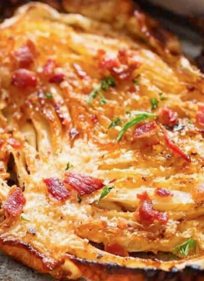 thick slice of cabbage roasted in the oven with crispy bacon and parsley sprinkled on top.