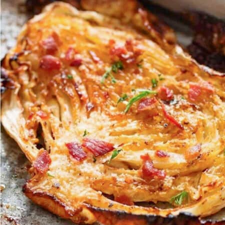 thick slice of cabbage roasted in the oven with crispy bacon and parsley sprinkled on top.