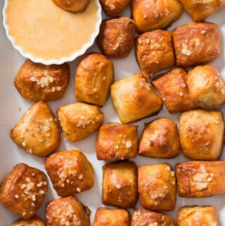 homemade pretzel bites on white tray with cheese sauce