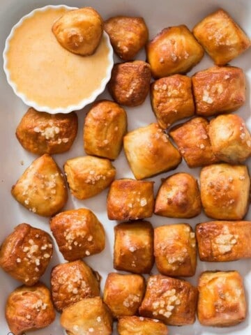 homemade pretzel bites on white tray with cheese sauce