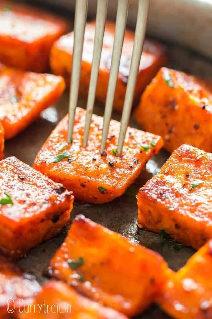oven roasted sweet potatoes on baking tray garnished with parsley