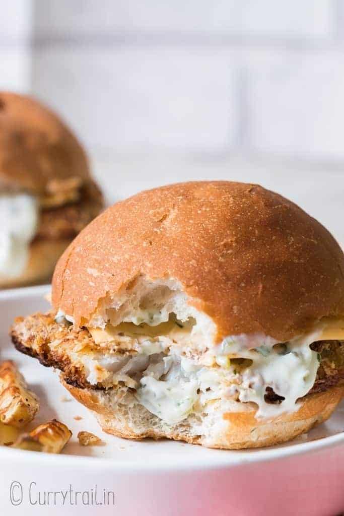 baked fish burger on white plate and red napkin